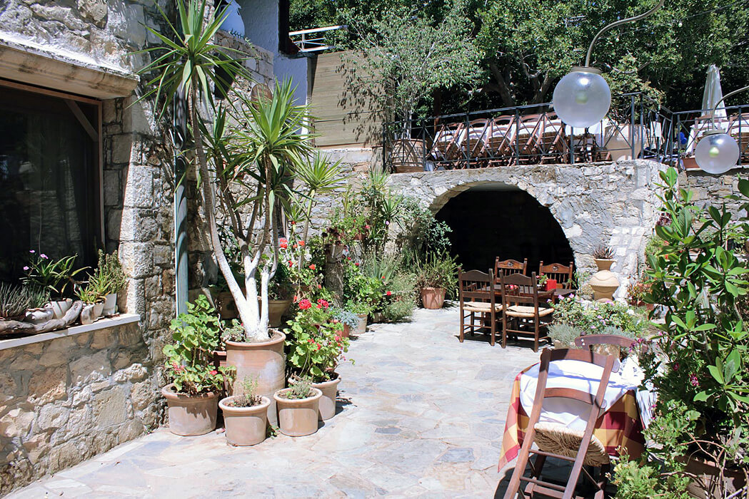Hotel Arolithos Traditional Cretan Village - stoliki wśród zieleni